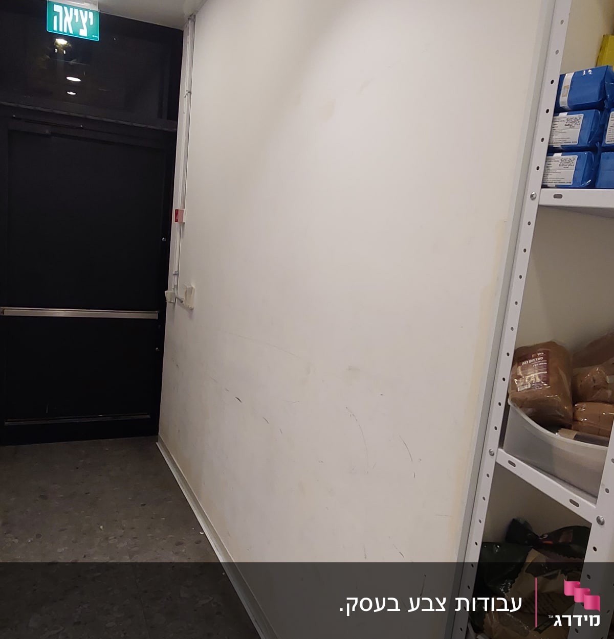 קיר לבן עם סימני לכלוך ודלי עם מטלית